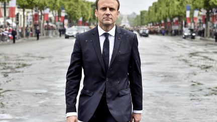 Sous la pluie, Emmanuel Macron participe à sa première cérémonie de ravivage de la Flamme du Souvenir sur la tombe du Soldat inconnu, sous l'Arc de Triomphe. (ALAIN JOCARD / AFP)