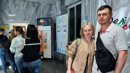 Loin de Melitopol, Iryna et Pavlo patientent devant un centre d’aide de Zaporijjia (Ukraine). (CAMILLE MAGNARD - LAURENT MACCHIETTI / RADIOFRANCE)