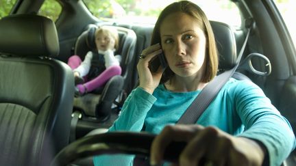 Selon un sondage OpinionWay publi&eacute; le 23 juillet 2012, 20% des parents t&eacute;l&eacute;phonent au volant alors que leurs enfants sont dans la voiture. (GETTY IMAGES)