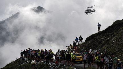 Des spectateurs rassemblés au Col du Portet pour regarder les coureurs du Tour de France, le 25 juillet 2018. (JEFF PACHOUD / AFP)