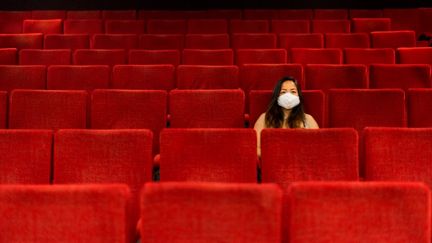 Une spectarice masquée dans une salle de théâtre vide. (ST?PHANE FERRER YULIANTI / HANS LUCAS)