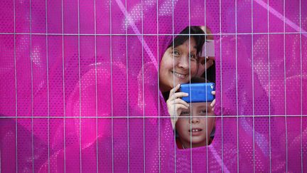 Des spectateurs ont fait un petit trou pour assister aux &eacute;preuves de cyclisme, le 1er ao&ucirc;t 2012 aux JO de Londres.&nbsp; (MARK BLINCH / REUTERS)