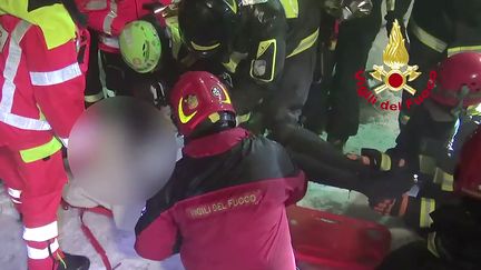 Des pompiers en train d'extraire une personne enfouie sous les décombres le 21 janvier 2017 près de Farindola (Italie). (AFP)