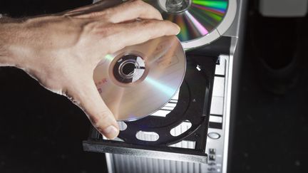 Un CD-ROM posé sur le chariot d'une tour centrale d'un ordinateur de bureau. Photo d'illustration. (GAETAN BALLY / MAXPPP)