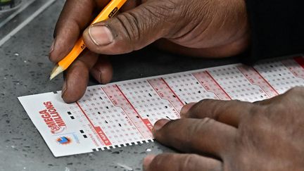 Un joueur remplit une grille de la loterie Mega Millions à Hawthorne (Californie, Etats-Unis), le 27 décembre 2024. (FREDERIC J. BROWN / AFP)