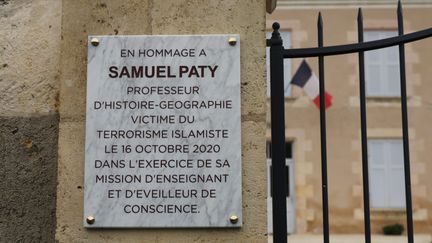 Plaque en hommage à Samuel Paty, professeur d'histoire-géographie assassiné près de son collège à Conflans-Sainte-Honorine (Yvelines), le 16 octobre 2020. (TROULLIAUD / MAXPPP)