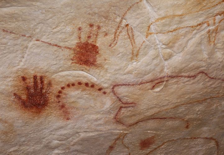 Traces de mains et figures animales de la grotte Chauvet reproduites dans sa réplique Chauvet 2, à Vallon-Pont-d'Arc, dans l'Ardèche. (PATRICK AVENTURIER / GROTTE CHAUVET 2 ARDECHE)