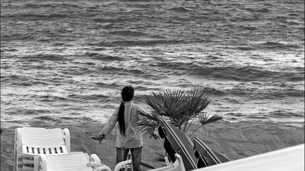 Fin d'après-midi, une Chinoise fait sa gymnastique traditionnelle dos à l'agitation  de la Croisette, face à la mer.
 (Jean-François Lixon)