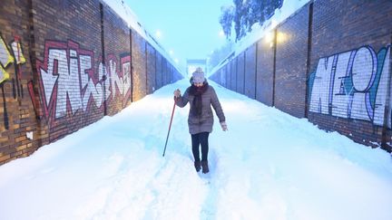 Une femme marche sur une route enneignée de Madrid, le 9 janvier 2021. (JUAN CARLOS LUCAS / NURPHOTO / AFP)