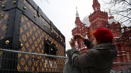 Une femme photographie la malle g&eacute;ante Louis Vuitton install&eacute;e sur la place Rouge de Moscou, mercredi 27 novembre 2013. (YURI KADOBNOV / AFP)