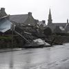 Des piétons passent devant un entrepôt détruit par la tempête Ciaran à Porspoder (Finistère), le 2 novembre 2023. (DAMIEN MEYER / AFP)