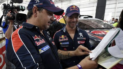 Sébastien Loeb et Daniel Elena (Peugeot) aux vérifications administratives et techniques du Dakar 2016 (FRANCK FIFE / AFP)