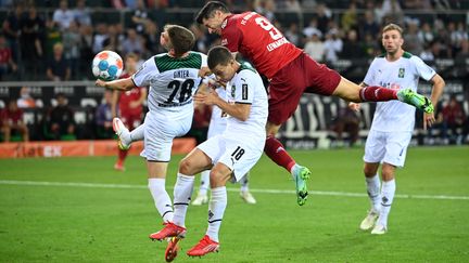 Robert Lewandowski&nbsp;s'impose dans le domaine aérien devant&nbsp;Matthias Ginter et Stefan Lainer, le 13 août à&nbsp;Moenchengladbach. (INA FASSBENDER / AFP)