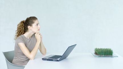 Une femme réflechit devant son ordinateur. (MATTHIEU SPOHN / MAXPPP)