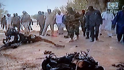 Capture d'&eacute;cran d'une vid&eacute;o diffus&eacute;e par T&eacute;l&eacute; Sahel montrant&nbsp;l'&eacute;pave du v&eacute;hicule de l'attentat suicide contre la base militaire d'Agadez, dans le nord du Niger, le 23 mai 2013. (TELE SAHEL / AFP)