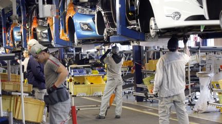 Des salari&eacute;s de PSA Peugeot-Citro&euml;n assemblent la Peugeot 207 dans l'usine de Poissy (Yvelynes), le 27 janvier 2012. (THOMAS SAMSON / AFP)