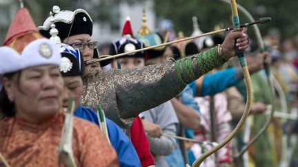 Des femmes mongoles participent &agrave; une concours de tir &agrave; l'arc lors d'un &eacute;v&egrave;nement sportif &agrave; Oulan Bator (Mongolie), le 11 juillet 2012. (ANDY WONG / AP / SIPA)