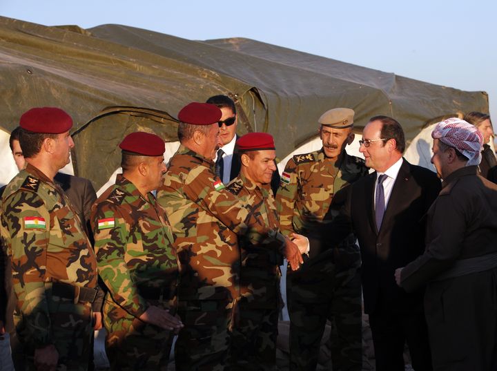 François Hollande salue des soldats kurdes peshmergas dans une base située au nord de Mossoul (Irak), lundi 2 janvier 2017, en compagnie du président de la région autonome Massoud Barzani (à droite). (CHRISTOPHE ENA / POOL / AFP)