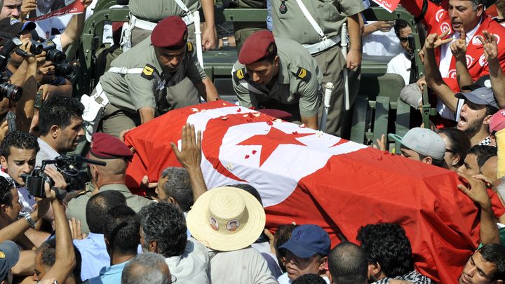 Des militaires chargent le cercueil du d&eacute;put&eacute; d'opposition assassin&eacute; Mohamed Brahmi &agrave; bord d'un v&eacute;hicule,&nbsp;le 27 juillet 2013 &agrave; Tunis (Tunisie), lors des fun&eacute;railles de l'opposant tu&eacute;. (FETHI BELAID / AFP)