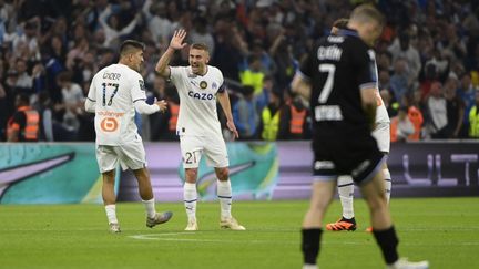 Valentin Rongier félicite Cengiz Ünder, auteur de l'égalisation face à Auxerre, le 30 avril 2023. (CLEMENT MAHOUDEAU / AFP)