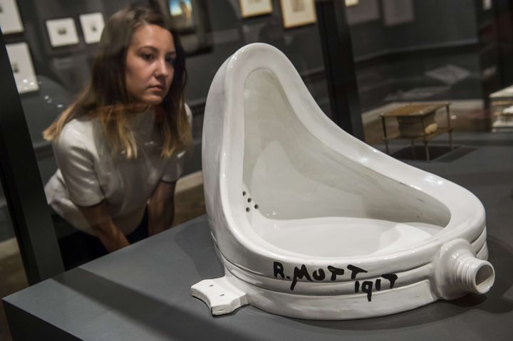 Une spectatrice observe "Fontaine", œuvre fondatrice de Marcel Duchamp, lors d'une explosition à la&nbsp;Royal Academy of Arts à Londres, le 3 octobre 2017. (GUY BELL / SIPA)