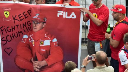 Des supporters de Ferrari brandissent une banderole de soutien à Michael Schumacher.  (GIUSEPPE CACACE / AFP)