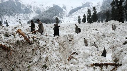 recherchent leurs biens à Ramwari, le 23 février 2012.

Les avalanches au Cachemire sont courantes.Trois ont eu lieu dans la région, le 23 février 2012.

A Dawar et Sonamarg, ces sont deux campements de l'armée indienne qui sont emportés par la neige. Seize soldats périssent, trois sont portés disparus.

A Ramwari, seules des cabanes de villageois et des tentes militaires sont touchées, sans faire de victimes. (AFP PHOTO / Rouf BHAT)