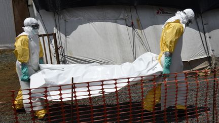 Deux membres de SOS m&eacute;decins transportant le corps d'une victime, le 27 septembre 2014 &agrave; Monrovia (Liberia).&nbsp; (PASCAL GUYOT / AFP)