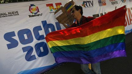 Un homme brandit un drapeau arc-en-ciel, symbole de la communaut&eacute; LGBT, devant l'ambassade de Russie &agrave; Mexico (Mexique) pour protester contre les discriminations subies par les homosexuels dans le pays, le 5 f&eacute;vrier 2014. (REUTERS)