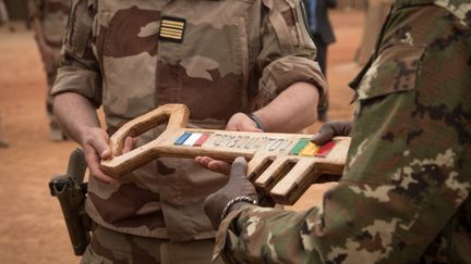 Le colonel Faivre donne la clé symbolique de l'opération Barkhane au colonel malien pendant une cérémonie de départ de l'armée française de la base militaire de Tombouctou (Mali), le 14 décembre 2021. (FLORENT VERGNES / AFP)