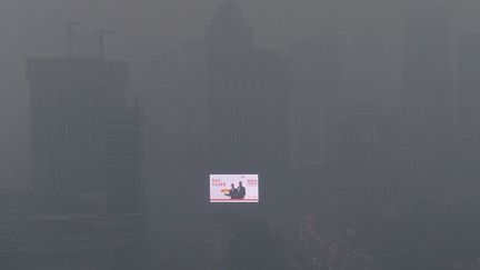 Un panneau publicitaire dans le brouillard caus&eacute; par une intense pollution &agrave; Shenyang (Chine), le 28 octobre 2013. (SHENG LI / REUTERS)