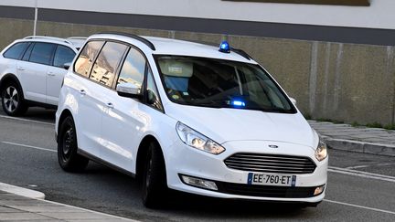 Une voiture de police transportant Nordahl Lelandais arrive au palais de justice de Grenoble (Isère) le 19 mars 2018. (JEAN-PIERRE CLATOT / AFP)