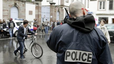 Un policier assure la surveillance de la sortie d'un lyc&eacute;e du centre-ville de Strasbourg (Bas-Rhin), le 17 mai 2013. (MAXPPP)