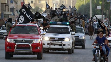 Des combattants du groupe&nbsp;Etat islamique paradent dans les rues de Raqqa&nbsp;(Syri), le 30 juin 2014. (REUTERS)