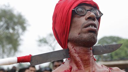 Un d&eacute;vot hindou avec la gorge transperc&eacute;e par un couteau participe au rituel "Chadak" &agrave; Krishanadevpur (Inde), le 13 avril 2012. (RUPAK DE CHOWDHURI / REUTERS)