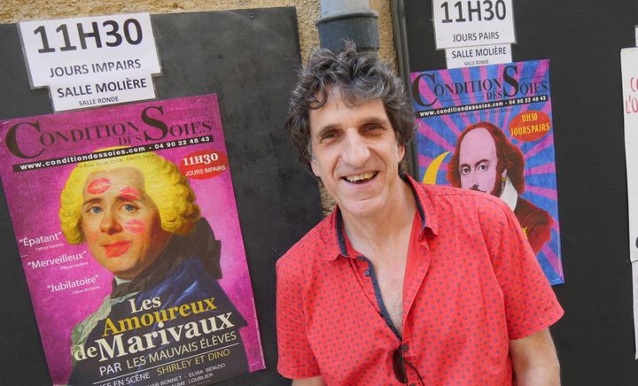 Gilles Benizio, alias Dino, devant le théâtre de la Condition des soies, à Avignon, le 6 juillet. Derrière lui les affiches des spectacles mis en scène par Shirley et Dino et avec notamment leur fille Elisa Benizio.
 (Lorenzo Ciavarini Azzi/Culturebox)