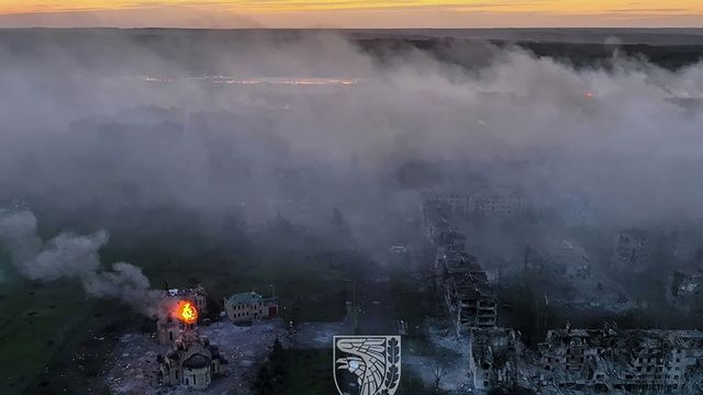 A thick cloud of smoke covers the city of Bakhmout in this photo released on May 21, 2023 by Ukrainian forces.  A building burns in the foreground.  (ARMED FORCES OF UKRAINE / AFP)