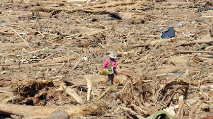 Une femme collecte des objets apr&egrave;s le passage du typhon Washi &agrave; Iligan (Philippines), le 20 d&eacute;cembre 2011. (TED ALJIBE / AFP)