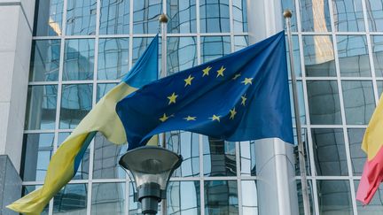 Les drapeaux de l'Ukraine et de l'Union européenne flottent à Bruxelles, en Belgique, le 18 décembre 2023. (ADRIEN FILLON / HANS LUCAS / AFP)