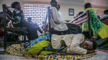 Une femme, couchée au sol, attend son tour pour prendre un rendez-vous à l'hôpital de Mulago qui vient de recevoir une nouvelle machine de radiothérapie le 19 janvier 2018, à Kampala, en Ouganda. Le centre hospitalier est un centre spécialisé dans le traitement du cancer qui accueille des patients de toute l'Afrique de l'Est.&nbsp; (SUMY SADURNI / AFP)