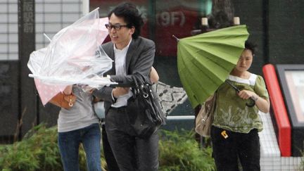 Des pi&eacute;tons luttent contre le vent &agrave; Osaka (Japon), le 19 juin 2012. (JIJI PRESS JAPAN OUT / AFP)