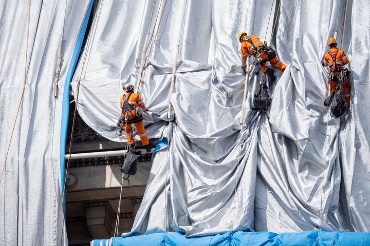 A Paris, l'empaquetage de l'Arc de Triomphe, oeuvre posthume de Christo, est entré dimanche 12 septembre dans le vif du sujet avec le premier "déroulé de tissu". (CARINE SCHMITT / HANS LUCAS / AFP)