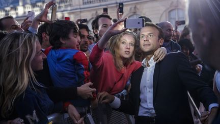 Le chef de l'Etat Emmanuel Macron multipliant les selfies, dans la cour de l'Elysée, le 21 juin 2018, à l'occasion de la Fête de la Musique. (CHRISTOPHE PETIT TESSON / AFP)