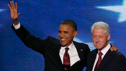 Le pr&eacute;sident am&eacute;ricain sortant Barack Obama (G) et Bill Clinton (D), dernier pr&eacute;sident d&eacute;mocrate avant lui, se rejoignent sur sc&egrave;ne, le 5 septembre 2012 &agrave; Charlotte (Caroline du Nord).&nbsp; (ALEX WONG / GETTY IMAGES NORTH AMERICA / AFP)