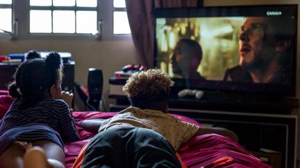 Zaina et Keesha tuent le temps devant la télévison, en attendant la rentrée tant espérée. (MATTHIEU MONDOLONI / FRANCEINFO)