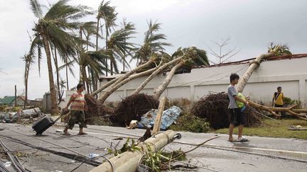 Des survivants du typhon Haiyan marchent dans la ville de Tacloban, le 9 novembre 2013, aux Philippines. (ROMEO RANOCO / REUTERS)