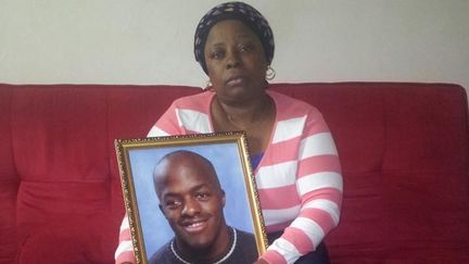 &nbsp; (Augustine Ngo Koumba pose avec une photo de Jonathan, son fils © RF-Sophie Parmentier)