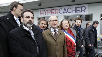 Bernard Cazeneuve (au centre, en costume kaki), devant l'Hyper Cacher de la porte de Vincennes, le 15 mars 2015 à Paris. (KENZO TRIBOUILLARD / AFP)