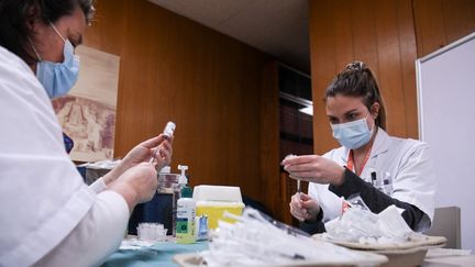 Des membres du personnel médical préparent le vaccin AstraZeneca-Oxford contre le Covid-19 à l'hôpital Mignot du Chesnay (Yvelines), le 7 février 2021. (ALAIN JOCARD / AFP)