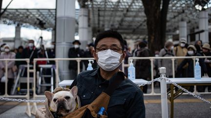 Un homme pose avec son chien, au Japon, en 2020. (PHILIP FONG / AFP)